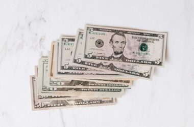 stack of different dollar banknotes on marble table