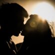 silhouettes of couple kissing against sunset